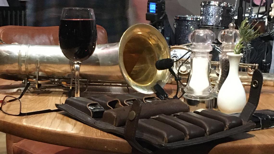 saxophone, blues harmonicas and a glass of wine on a pub table